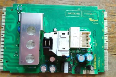 Płyta sterująca pralki Whirlpool, potencjalnie z błędem F08. Widoczne elementy to przekaźniki, kondensatory i radiator.
