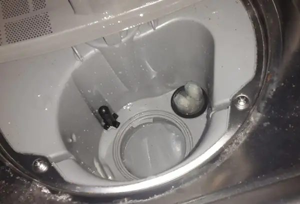 Wnętrze zmywarki Beko z błędem E01. Widoczny filtr i czujnik poziomu wody.